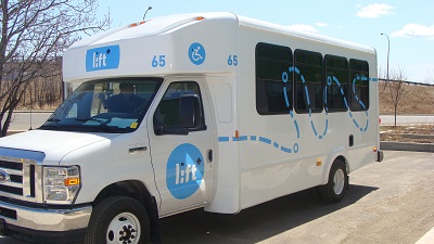 A white Lift bus sitting outside awaiting use