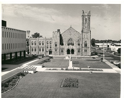 the green space in front of City Hall with a church in the distance