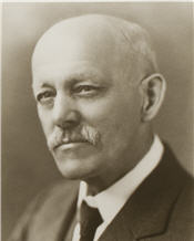 Mayor E. S. Rutledge sitting for a black and white photo wearing a black suit