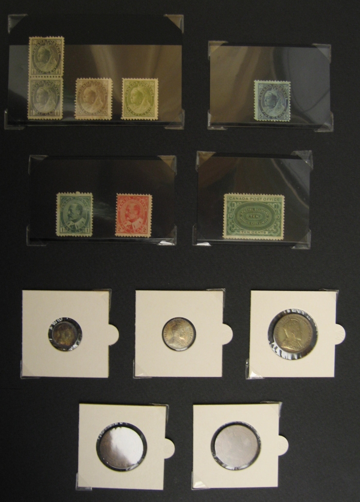 A black sheet with various small coins and stamps taped to it