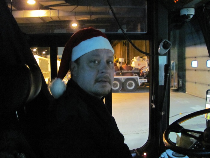 a transit employee driving the Santa bus with his Santa cap on