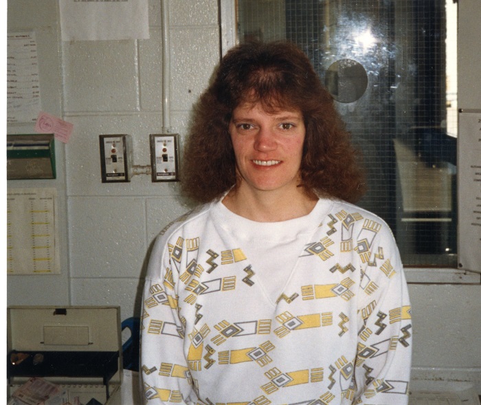 a woman standing and facing the camera while smiling