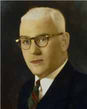 Mayor Charles Cox wears a brown suit and gold tie