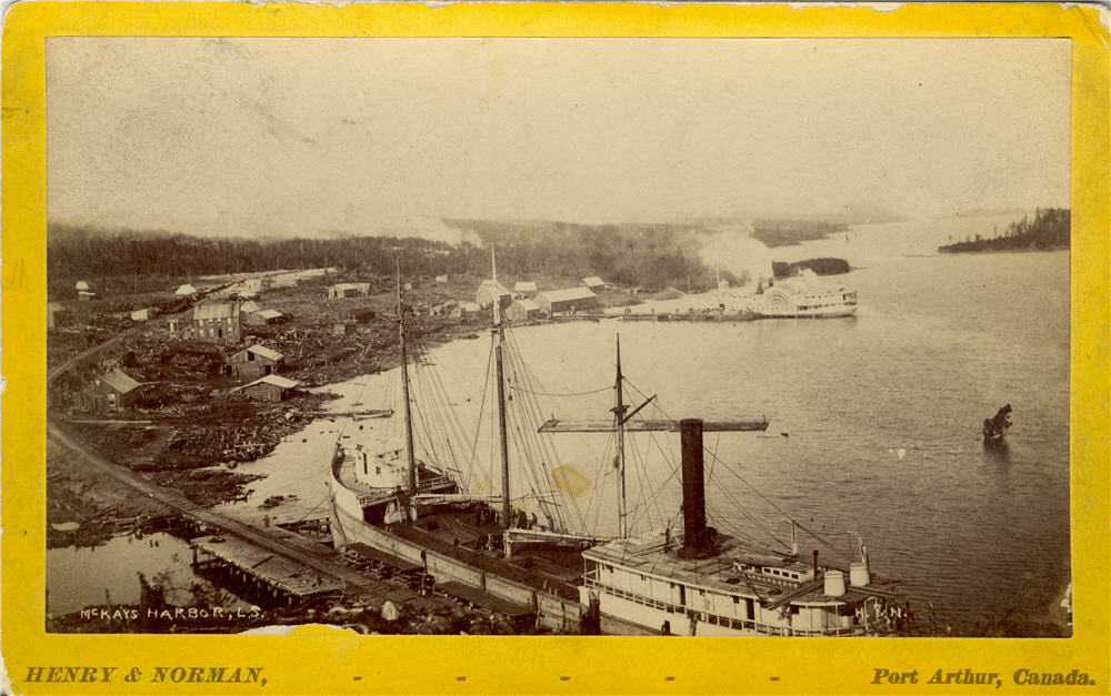 View of harbour, two ships at docks, railroad tracks in foreground