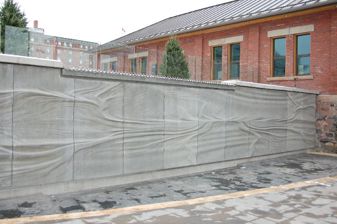 Embedded History sculpture near Baggage Building with a wave-like texture