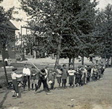 A line of children walking through the woods holding hands