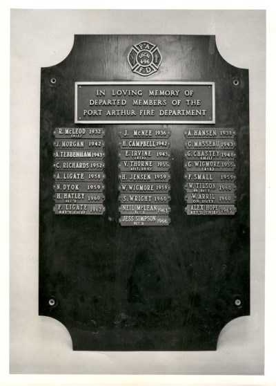 A wooden plauqe with metal name cards listing those who have passed