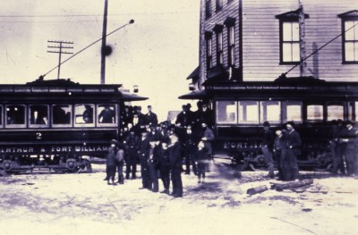 Two buses face each other with a crowd of people in front