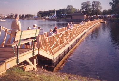 A wooden bridge built across the water with people walking along