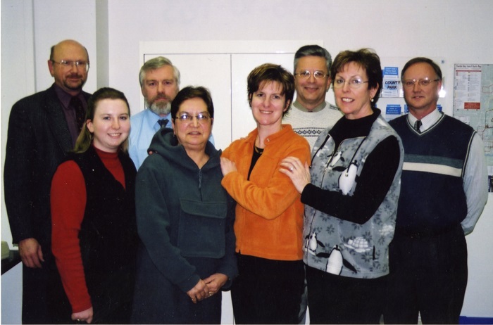 A group of men and women standing and posing for a photo