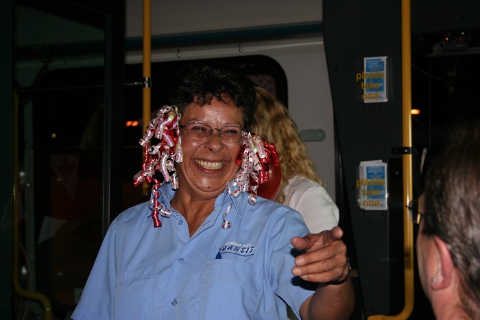 A person standing and pointing while wearing ribbons on her ears