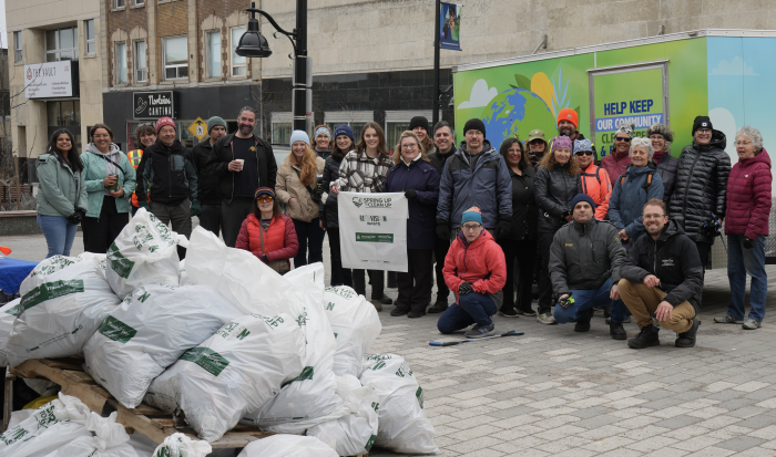 group of people on street with pile of garbage bags