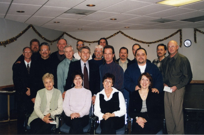 A group of men and women standing together smiling at the camera