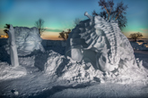 a snow sculpture of a dinosaur and the mythical figure of Poseidon