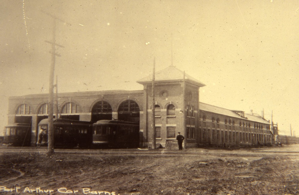 the Port Arthur car barns with street cars emerging from the barn
